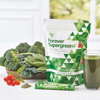 eine schale broccoli, daneben ein beutel supergreens und glas gefüllt mit trank